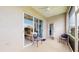 Cozy screened patio with seating, sliding glass doors, and an adjacent doorway to interior at 22316 Red Jacket Ln, Land O Lakes, FL 34639