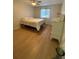 Bright bedroom with wood floors featuring a bed and a dresser with a floral arrangement at 2270 Alden Ln # A, Palm Harbor, FL 34683