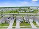 Aerial view of a residential area featuring houses, green spaces, a pool, and a community center at 2572 Garden Plum Pl, Odessa, FL 33556