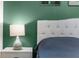 Bedroom detail: a bedside lamp with a green-painted wall in the background at 2572 Garden Plum Pl, Odessa, FL 33556