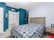 Blue-themed bedroom with a patterned bedspread and attached bathroom at 2572 Garden Plum Pl, Odessa, FL 33556