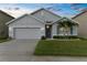 Well-maintained single-Gathering home featuring a lush green lawn and palm trees at 2572 Garden Plum Pl, Odessa, FL 33556