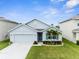 Charming single-story home with well-manicured lawn, landscaped garden, and a two-car garage at 2572 Garden Plum Pl, Odessa, FL 33556