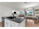 Open concept kitchen features modern countertops, a black sink, and a view into the dining and living spaces at 2572 Garden Plum Pl, Odessa, FL 33556