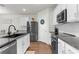 Bright kitchen featuring stainless steel appliances, white cabinets, granite countertop, and hardwood floors at 2572 Garden Plum Pl, Odessa, FL 33556