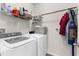 Functional laundry room with washer, dryer, and shelving for storage at 2572 Garden Plum Pl, Odessa, FL 33556