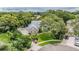 An elevated view of a home's landscaped yard, stone accents, and mature trees at 2880 Chelsea N Pl, Clearwater, FL 33759