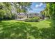 Expansive backyard with mature trees and lush landscaping, featuring a fully screened pool enclosure at 2880 Chelsea N Pl, Clearwater, FL 33759