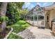 Professionally landscaped backyard with lush green grass, a patio, and a fully screened outdoor pool area at 2880 Chelsea N Pl, Clearwater, FL 33759