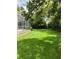 Spacious backyard with lush green lawn and screened-in porch area at 2880 Chelsea N Pl, Clearwater, FL 33759