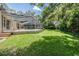 Sprawling backyard with manicured lawn, mature trees, and a screened-in pool area perfect for outdoor living at 2880 Chelsea N Pl, Clearwater, FL 33759