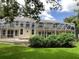 Exterior rear of home featuring a pool in a screened enclosure and large landscaped backyard at 2880 Chelsea N Pl, Clearwater, FL 33759