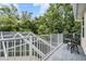 Balcony with a pool view, a table and chairs, white railings, and lush landscaping at 2880 Chelsea N Pl, Clearwater, FL 33759