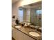 Bathroom with double sink vanity, granite countertop, a soaking tub, and a glass block shower at 2880 Chelsea N Pl, Clearwater, FL 33759