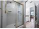 Bathroom with a tiled shower and a glass door, a granite countertop, and tile floors at 2880 Chelsea N Pl, Clearwater, FL 33759