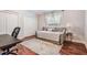 Neutral bedroom features a cozy daybed, wood floors, a patterned rug, and a large window at 2880 Chelsea N Pl, Clearwater, FL 33759