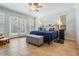 Sun-filled main bedroom boasts a plush bed, neutral tones, and access to the backyard through sliding doors at 2880 Chelsea N Pl, Clearwater, FL 33759