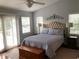 Bedroom featuring a tufted headboard and doors to a balcony at 2880 Chelsea N Pl, Clearwater, FL 33759