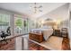 Bright bedroom with a bed, a chest, wood floors, and a balcony with sliding glass doors at 2880 Chelsea N Pl, Clearwater, FL 33759