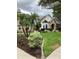 Beautifully landscaped front yard featuring palm trees and lush greenery at 2880 Chelsea N Pl, Clearwater, FL 33759