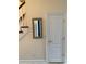 Hallway with a door and a framed mirror by the stairs at 2880 Chelsea N Pl, Clearwater, FL 33759