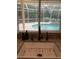Farmhouse sink overlooking the backyard pool through a window with slatted blinds at 2880 Chelsea N Pl, Clearwater, FL 33759