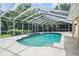 Stunning screened-in pool featuring an attached spa, clear blue water, and a serene outdoor space at 2880 Chelsea N Pl, Clearwater, FL 33759