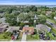 Aerial view of a residential home, with lush trees, surrounding community and a glimpse of the ocean at 2887 Cathy Ln, Clearwater, FL 33760