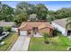 An attractive home with a manicured lawn, one-car garage, private driveway, and mature shade trees at 2887 Cathy Ln, Clearwater, FL 33760