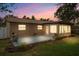 Charming backyard at dusk featuring a concrete patio, greenery and landscaping at 2887 Cathy Ln, Clearwater, FL 33760