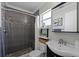Modern bathroom featuring gray tiled shower, pebble floor, and white vanity at 2887 Cathy Ln, Clearwater, FL 33760