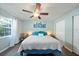 Light-filled bedroom with a ceiling fan, vinyl flooring, and window with sheer curtains at 2887 Cathy Ln, Clearwater, FL 33760