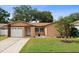 Charming single-story home featuring a well-manicured lawn and inviting curb appeal, complete with an attached garage at 2887 Cathy Ln, Clearwater, FL 33760