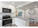 Bright kitchen features white cabinets, stainless steel appliances, breakfast bar with seating at 2887 Cathy Ln, Clearwater, FL 33760