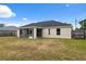 A view of the back of the house with a screened-in porch and fenced-in backyard at 3312 Blythe Ave, Spring Hill, FL 34609