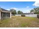 Spacious backyard featuring a white fence and a screened-in porch, perfect for outdoor entertaining at 3312 Blythe Ave, Spring Hill, FL 34609