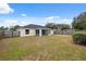 Large backyard with a partial view of the house, screened-in porch, and a sturdy wooden fence at 3312 Blythe Ave, Spring Hill, FL 34609