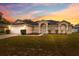 Beautiful sunset illuminating the exterior of this lovely home, showcasing manicured landscaping and a welcoming entrance at 3312 Blythe Ave, Spring Hill, FL 34609