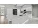 Bright kitchen with white cabinets, stainless steel appliances, and a large island with quartz countertops at 3312 Blythe Ave, Spring Hill, FL 34609