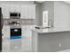 The kitchen is updated with stainless steel appliances, white cabinets, and grey countertops at 3312 Blythe Ave, Spring Hill, FL 34609