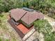 Aerial view of the home featuring a new roof, landscaping and treed lot at 34335 Berryhill Dr, Webster, FL 33597