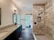 Bathroom featuring a walk-in tiled shower, granite countertops, double vanity, and hardwood style floors at 34335 Berryhill Dr, Webster, FL 33597