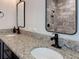 Bathroom features double sinks with a granite countertop, dark cabinets, and bronze fixtures at 34335 Berryhill Dr, Webster, FL 33597