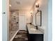 Bathroom boasts double sinks, granite countertop, dark cabinets, and a tiled shower at 34335 Berryhill Dr, Webster, FL 33597