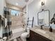 Bathroom featuring decorative mirror, granite countertop, tiled walls, and shower over tub at 34335 Berryhill Dr, Webster, FL 33597