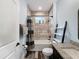 Bathroom featuring decorative mirror, granite countertop, tiled walls, and shower over tub at 34335 Berryhill Dr, Webster, FL 33597