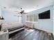 Well-lit bedroom with hardwood style floors, rustic wood furniture, a decorative ceiling fan, and a sliding barn door at 34335 Berryhill Dr, Webster, FL 33597
