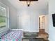 Bedroom features a ceiling fan, a window looking onto trees, wood-look floors and closet at 34335 Berryhill Dr, Webster, FL 33597