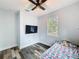 Bedroom featuring window view, ceiling fan, mounted television, and wood-look floors at 34335 Berryhill Dr, Webster, FL 33597