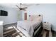 Bright bedroom featuring hardwood style floors, a decorative ceiling fan, and a rustic wood bed frame at 34335 Berryhill Dr, Webster, FL 33597
